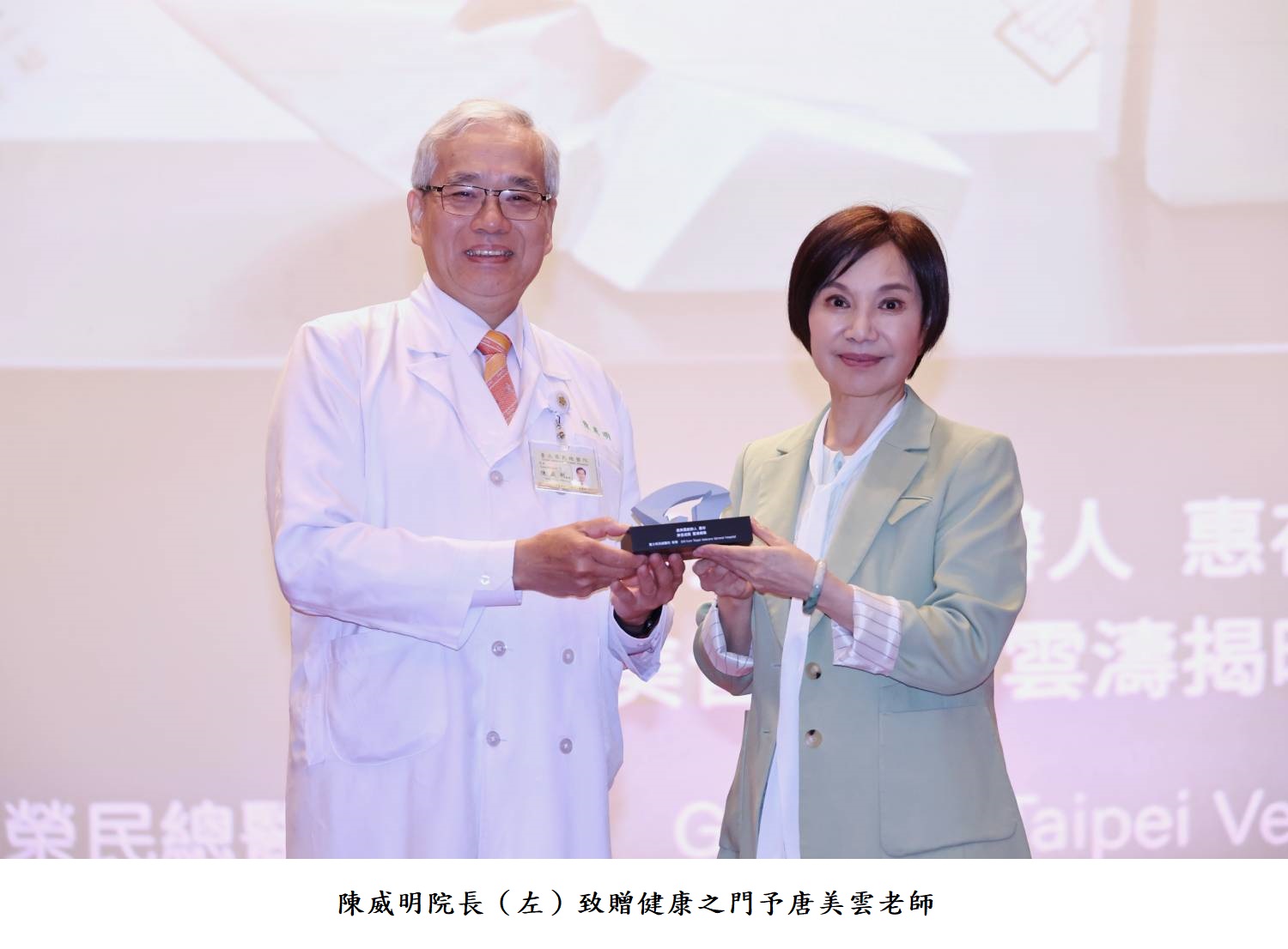 陳威明院長（左）致贈健康之門予唐美雲老師